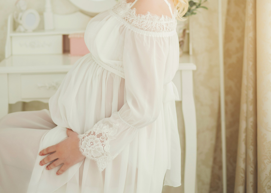pregnant woman sitting and holding her belly.