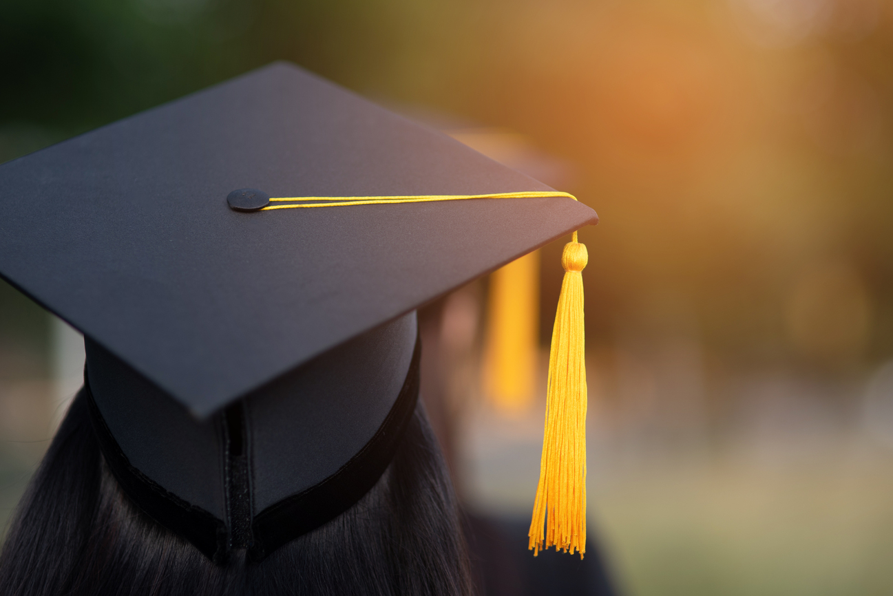 Back portrait of graduated wearing a black hat.