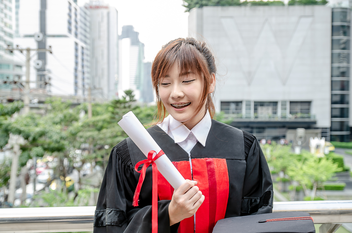 happy university students asian woman holding graduation diploma